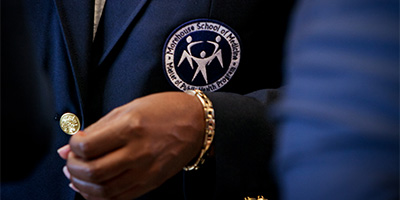 a closeup of an MPH program badge on a suit jacket